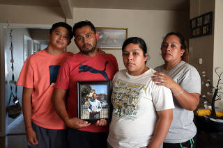 The Maldonado family, Benjamin Maldonado, Sr., second from left, and his wife Adriana Garcia right, with children Benjamine Maldonado, Jr, left, and Xitlali Raya Garcia, second from right, pose at their San Lorenzo, Calif. home on June 28, 2021, with a portrait of their son Jovani, 15, who was killed when a Tesla operating on autopilot rear-ended the family?s pickup truck. (Jim Wilson/The New York Times)