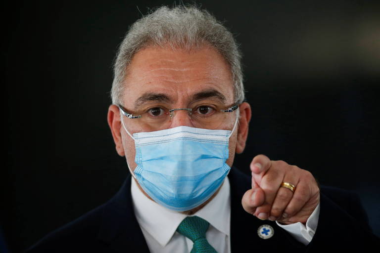 Imagem em primeiro plano mostra o ministro da Saúde, Marcelo Queiroga. Ele está de máscara apontando o dedo indicador para frente.