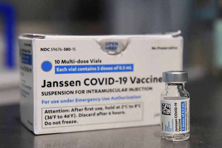 Caixa branca sobre mesa onde se lê " Janssen Covid-19 vaccine" e, na frente, um frasco da vacina