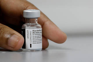 FILE PHOTO: A medical worker prepares to dilute a vial of Pfizer-BioNTech vaccine at a coronavirus disease (COVID-19) vaccination center in Singapore