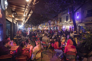 Extensao do horario  de bares ate as 23 horas. Pessoas consomem bebidas e alimentacao  na rua Guaicui (em Pinheiros) as 22h30 onde estao diversos bares