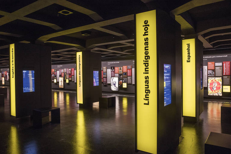 No segundo andar, totens interativos trazem palavras cruzadas; ao fundo, o painel Português do Brasil