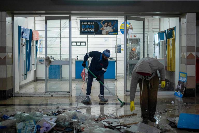 Moradores de Soweto, em Joanesburgo, limpam comércio destruído durante os protestos 