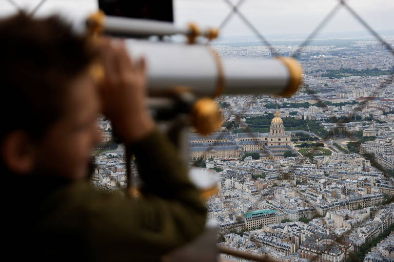 Um menino olha para um monumento da Torre Eiffel enquanto ela reabre suas portas para os turistas após seu fechamento no final de outubro de 2020