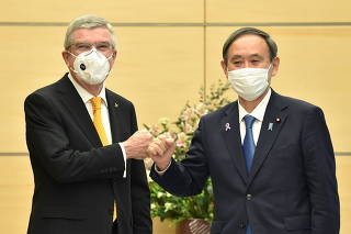 Japan's Prime Minister Yoshihide Suga greets International Olympic Committee (IOC) president Thomas Bach during their meeting in Tokyo