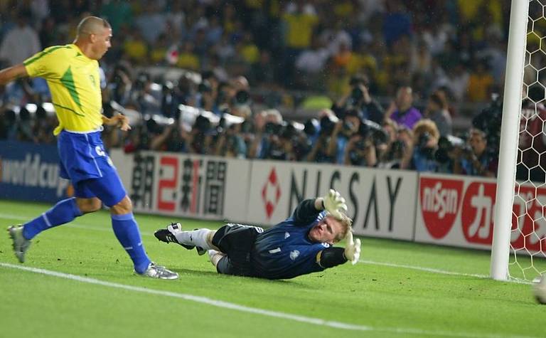 Após arremate de Rivaldo que o goleiro alemão Oliver Kahn não conseguiu agarrar, Ronaldo chuta para marcar o primeiro de seus dois gols na vitória da seleção brasileira diante da seleção alemã que deu o pentacampeonato para o Brasil na final da Copa do Mundo da Coréia e do Japão, em Yokohama (Japão)