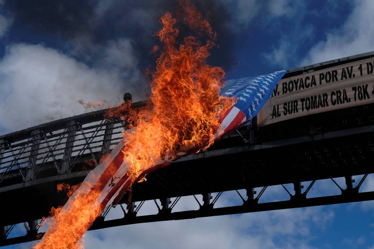 Manifestantes queimam bandeira dos EUA em protestos antigoverno em Bogotá no feriado da Independência da Colômbia
