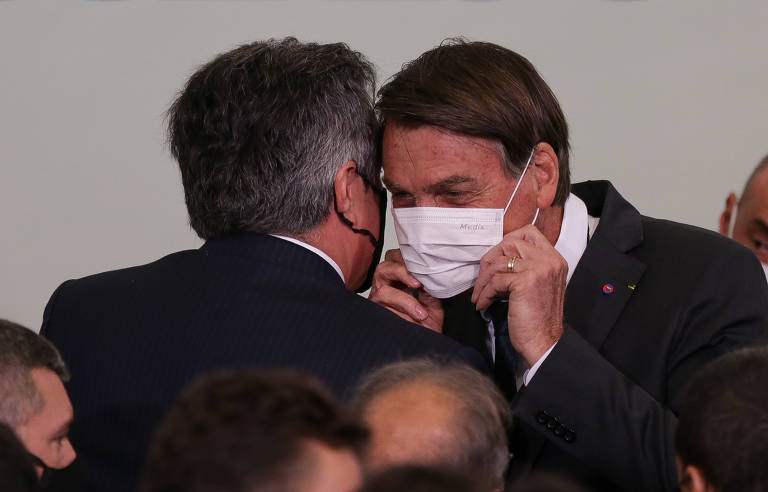 O presidente Jair Bolsonaro conversando com o presidente do PP, senador Ciro Nogueira (PP-PI), durante cerimônia de lançamento do programa Casa Verde Amarela, de financiamento de habitação. 