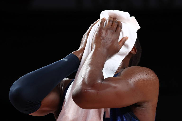 Bam Adebayo esconde o rosto com uma toalha branca após a derrota dos EUA para a França no basquete olímpico
