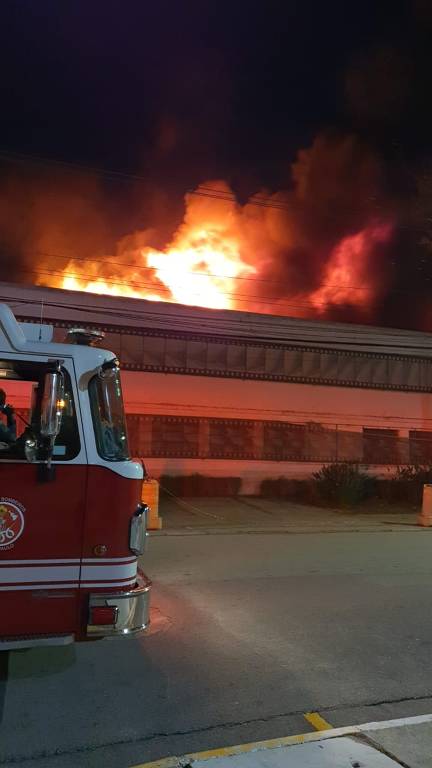 Caminhão de bombeiros em frente a uma instituição em chamas