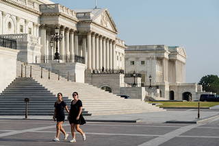 Women walk past the Capitol before a hearing on the January 6th attack on Capitol Hill in Washington