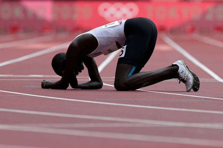 O corredor James Nyang Chiengjiek, do time de refugiados das Olimpíadas, caído no chão na disputa dos 800 m rasos