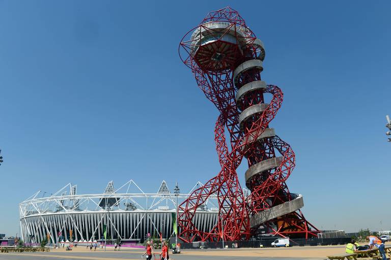Torre imensa, envolva por túneis enredados e vermelhos, ao lado do Estádio Olímpico