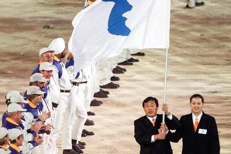 Representantes das Coreias do Sul e do Norte demonstram união e desfilam juntos na cerimônia de abertura da Olimpíada de Sydney-2000, o que não ocorria desde a Guerra da Coreia, em 1950