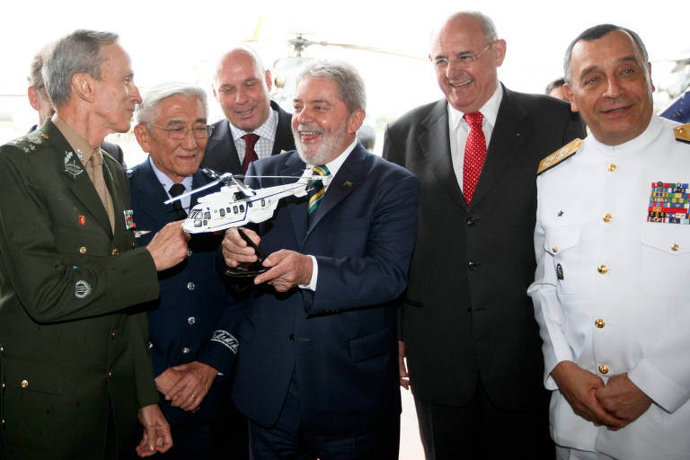 Lula com maquete de modelo de helicóptero que comprou da França para as Forças Armadas, acompanhado por Jobim (gravata vermelha) e os comandantes militares