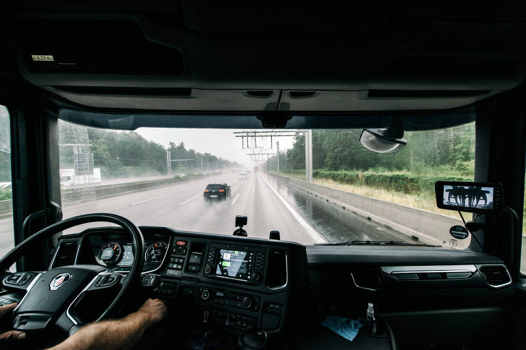 Visão de dentro de cabine do motorista de caminhão andando em rodovia