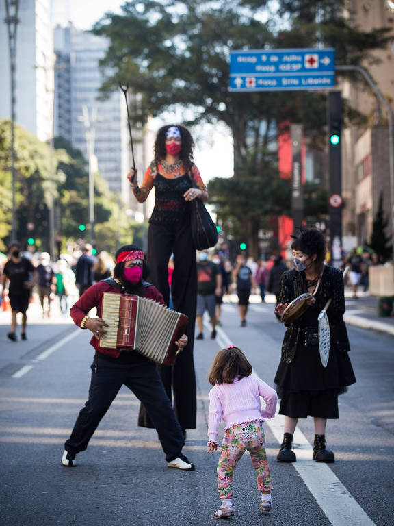 Criança se diverte com artistas circenses na Paulista fechada para carros
