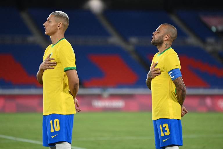 Richarlison e Daniel Alves escutam o hino brasileiro antes da estreia nos Jogos de Tóquio, contra a Alemanha