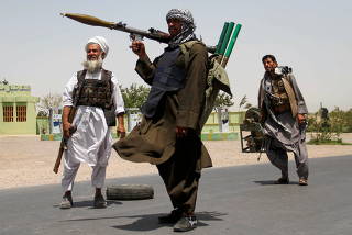 FILE PHOTO: Former Mujahideen hold weapons to support Afghan forces in their fight against Taliban, on the outskirts of Herat province