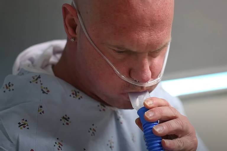 Russel Taylor usa aparelhos hospitalares para ajudar sua respiração