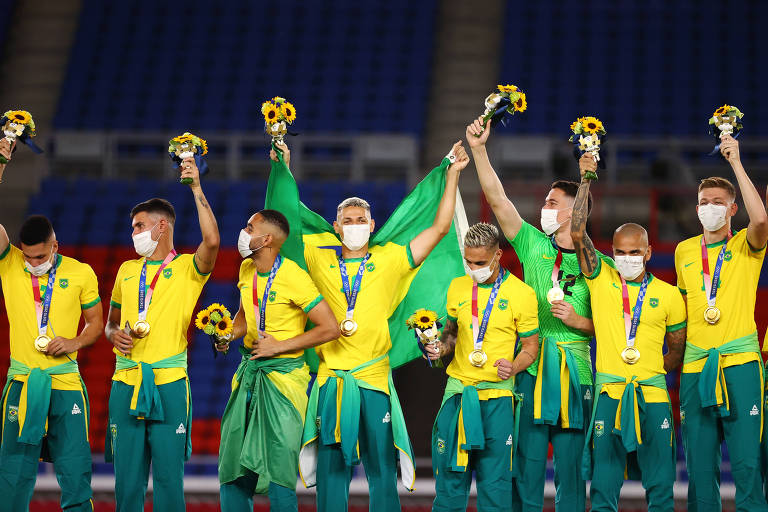 Jogadores de futebol celebram vitória em pódio