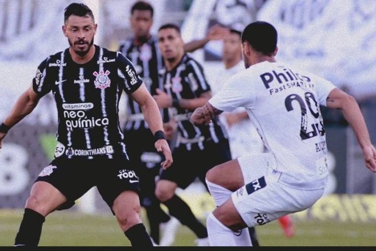 Giuliano e Camacho disputam a bola durante clássico entre Corinthians e Santos, na Vila Belmiro, pelo Brasileirão