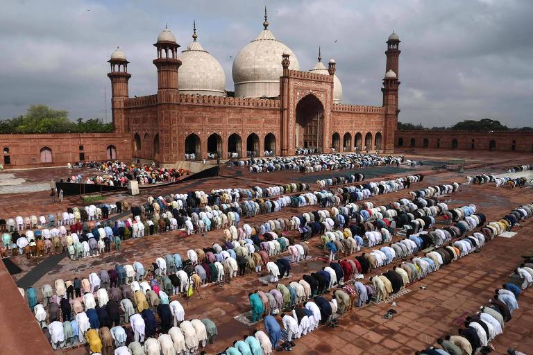 Muçulmanos oferecem orações em frente à mesquita histórica Badshahi, em Lahore, no Paquistão