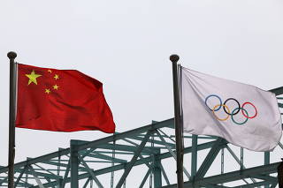 FILE PHOTO: Chinese national flag flutters next to an Olympic flag at the Beijing Organising Committee for the 2022 Olympic and Paralympic Winter Games, in Beijing