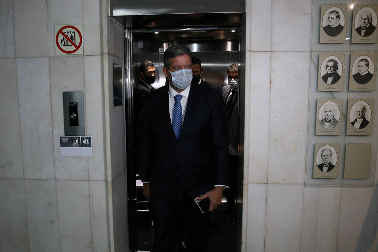 Arthur Lira, de máscara, saindo de um elevador, na Câmara