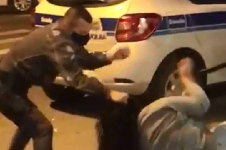 Imagem mostra um policial puxando os cabelos de uma mulher durante abordagem