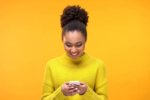 Smiling African-American woman chatting on smartphone, modern technology, app