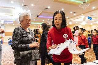 Alice Yi, right, explains about the United States census to a participant at a Vietnamese New Year Festival in Austin, Texas on Jan. 19, 2020. (Go Nakamura/The New York Times)
