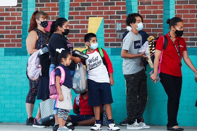 Pais levam os seus filhos às escolas infantis no primeiro dia de volta às aulas em meio à pandemia, em Tampa, Flórida