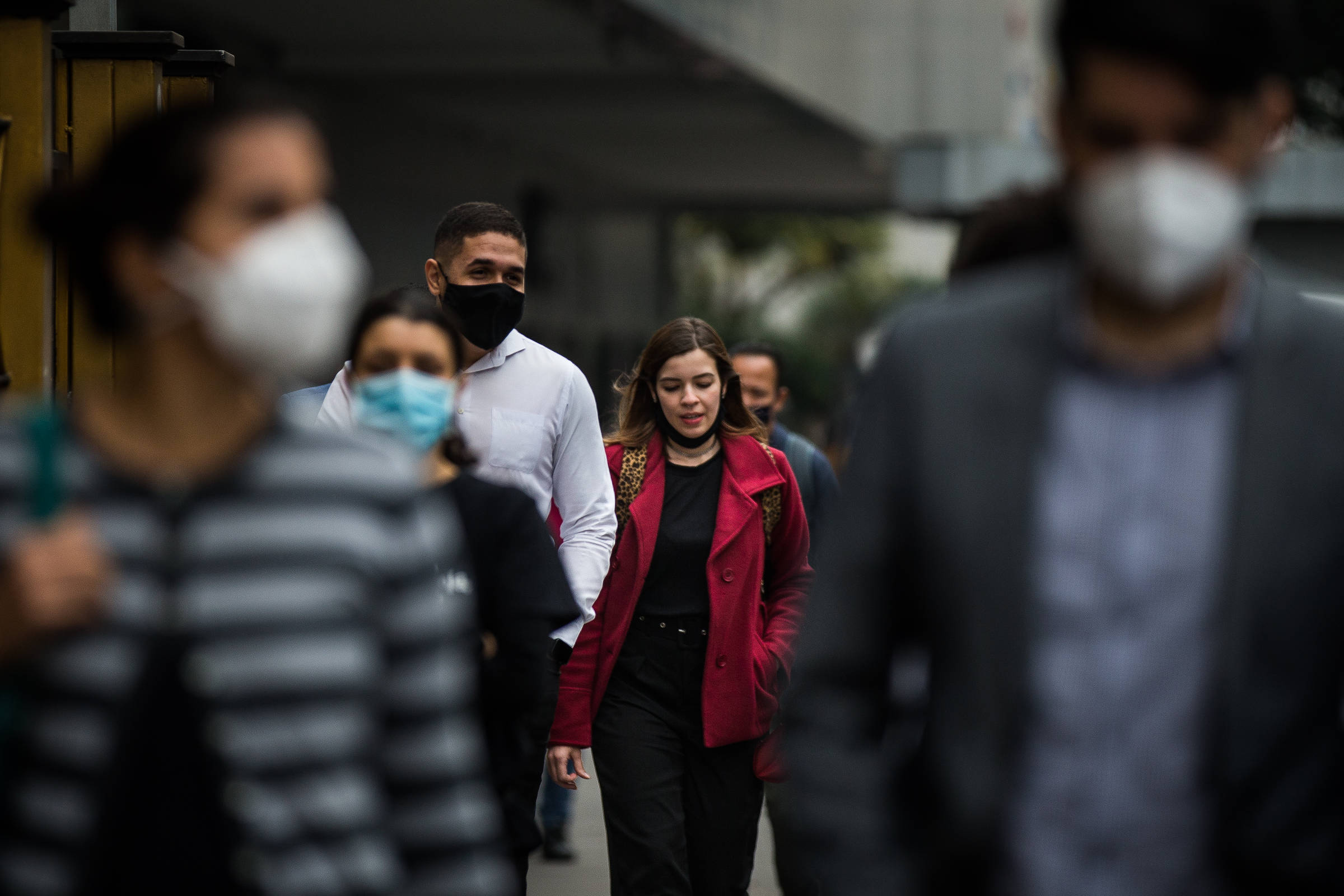 Pessoas andam pela avenida Paulista com roupas de frio 