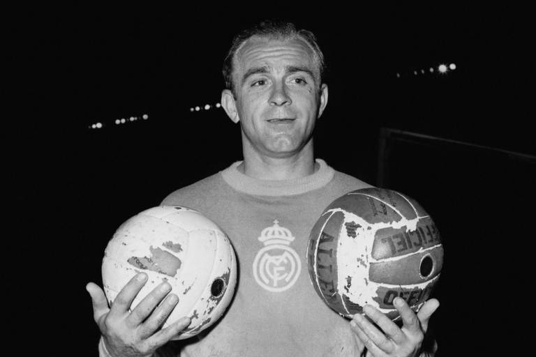 O então jogador de futebol Alfredo Di Stéfano posa em Paris com uma bola em cada mão, em 1956; a imagem é em preto e branco