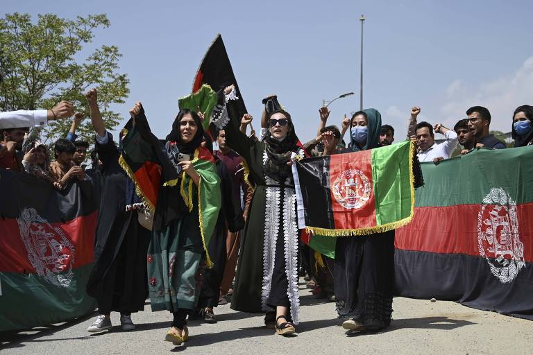 Homens e mulheres afegãs fazem protesto com bandeiras nacionais em Cabul
