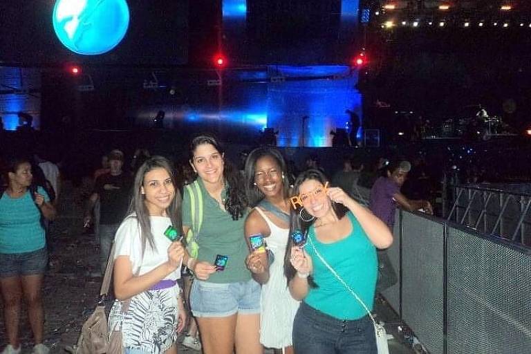 Quatro mulheres, três brancas e uma negra segurando ingressos do festival Rock in Rio