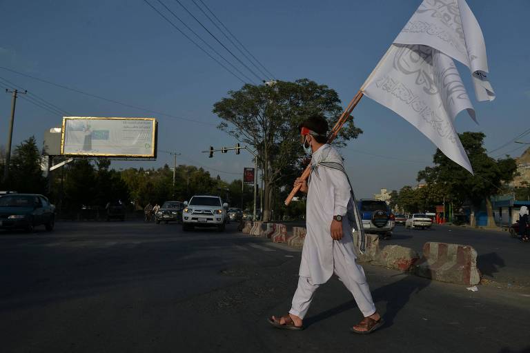 Homem com bandeira do Talibã em Cabul