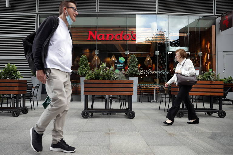 Pedestres caminham em frente a loja do Nando´s em Londres
