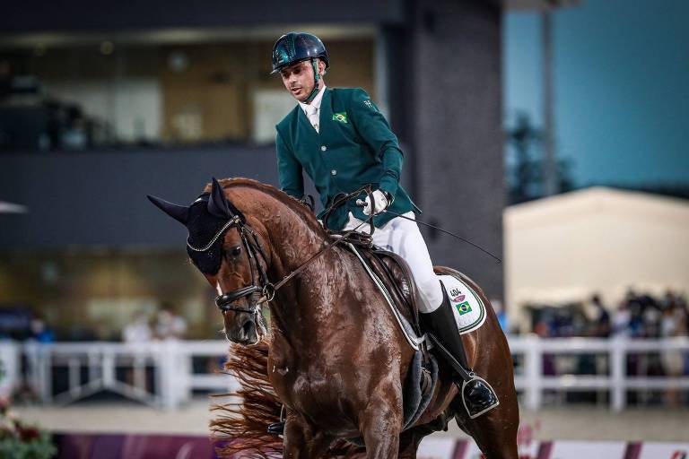 Rodolpho Riskalla, de roupa na cor verde e chapéu, sobre o cavalo na competição