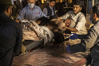 A person wounded in a bomb blast outside the Kabul airport in Afghanistan on Thursday, Aug. 26, 2021, arrives at a hospital in Kabul. (Victor J. Blue/The New York Times)