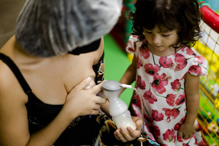 Letycia Sobreira com as filhas  Nina (2 anos) e Luna (8 meses) em casa e retirando leite para doação