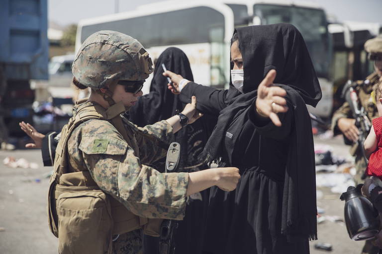 Militar americana revista mulher que tenta deixar o Afeganistão pelo aeroporto de Cabul