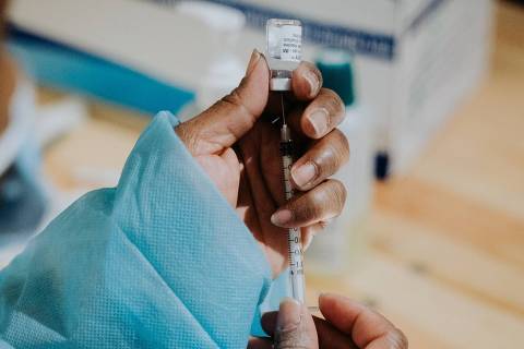 Vacina Web Stories - mãos puxando dose ampola de vacina contra a Covid-19 coronavírus com a seringa