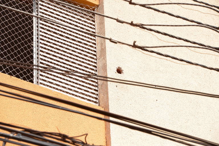 Marca de bala em edifício residencial atingido durante a ação dos criminosos
