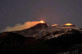 Large streams of red hot lava shoot into the night sky as Mount Etna, Europe's most active volcano, leaps into action, seen from the village of Fornazzo, in Catania, Italy