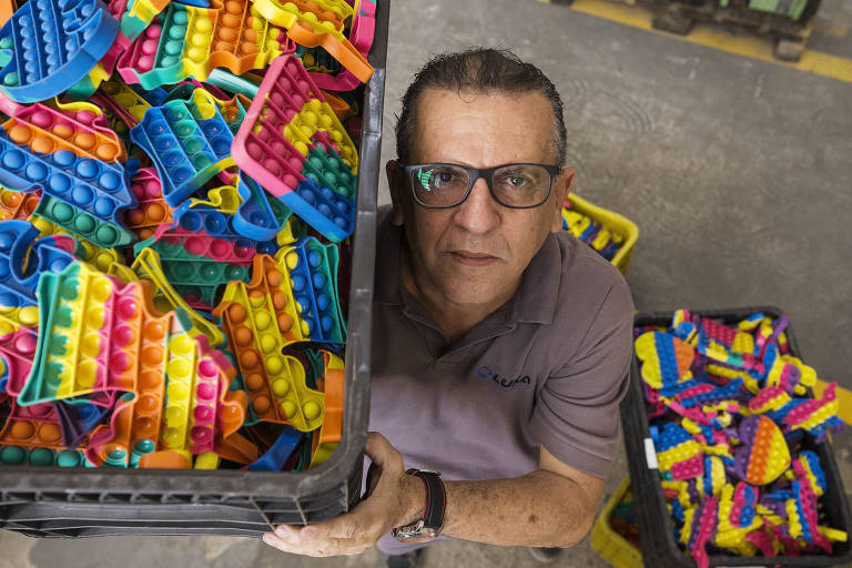 Homem de óculos segura caixa com pop-its