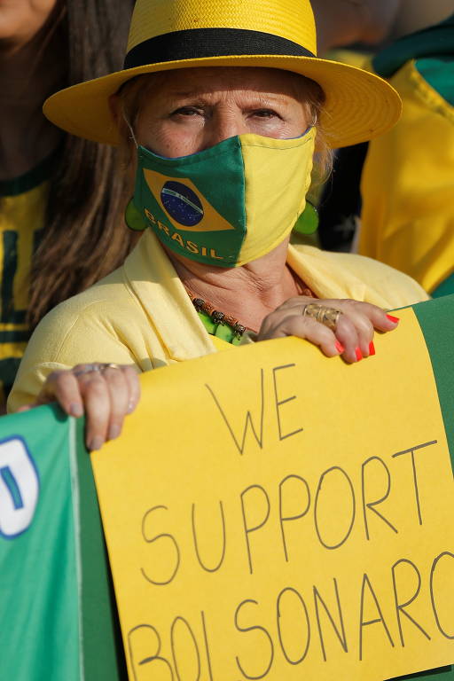 Mulher carrega faixa em que declara apoio a Jair Bolsonaro e aos protestos deste 7 de setembro, em Brasília
