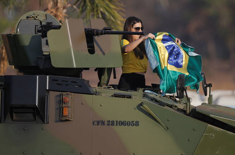 Manifestante mostra a bandeira do Brasil em cima de veículo blindado do Exército, em apoio ao presidente Jair Bolsonaro