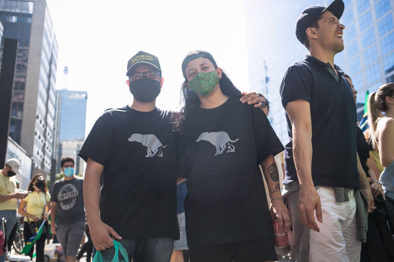 O casal Cesar Alexandre, 27, e Carolina Chimenez, 22, usavam camisetas pretas cujas estampas exibiam um cachorrinho fazendo cocô. As tais “fezes” caninas caem sobre o desenho da foice e do martelo, símbolos do trabalho no comunismo